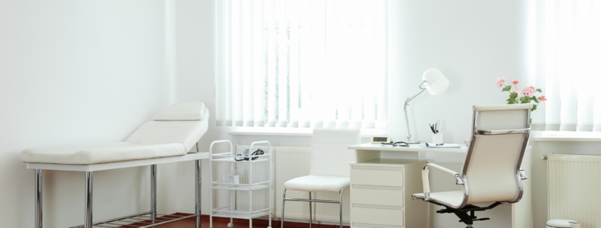 Healthcare Medical Cleaning in a clean medical exam room with examination table and workstation