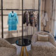 Luxury clothing boutique with organized displays, clean seating area, and neatly arranged apparel.