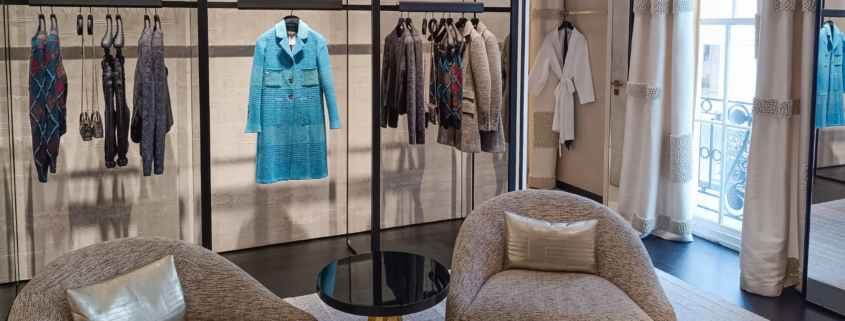 Luxury clothing boutique with organized displays, clean seating area, and neatly arranged apparel.