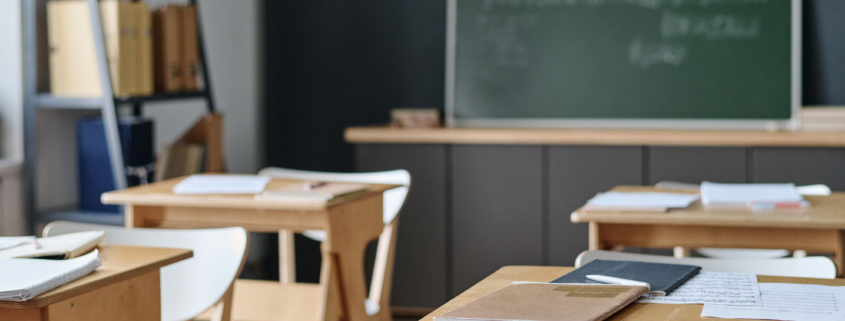 Organized classroom with wooden desks and chalkboard after professional cleaning.