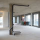 Commercial renovation project before final construction cleaning with exposed concrete and construction materials.