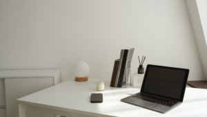 Clean office desk with laptop, phone, notebooks, and work accessories