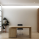 Clean executive office with large windows, wood desk, and storage cabinet