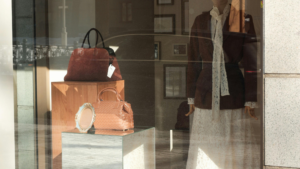 Clean retail storefront window with handbag display