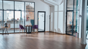 Clean commercial office common area with glass walls and wood floors